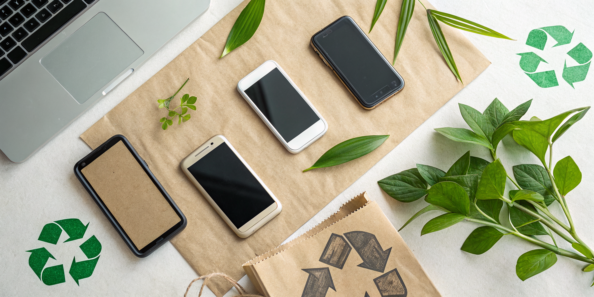 A flat lay composition showing a collection of old smartphones in various conditions arranged on a recycled paper surface,